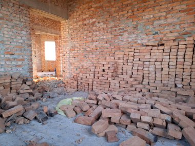 Tuğladan duvarları olan bitmemiş bir kulübenin içi. Yerleşim olmayan, tamamlanmamış bir bina.