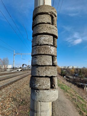 Demiryolundaki gerilim kablolarının ağırlığı. Silindirik beton bloklardan oluşan gerilim ağırlığı. Kablo gerilim ağırlığı ya da kutuptaki gerilim yükü. Demiryolundaki kablolu gerilim aygıtı