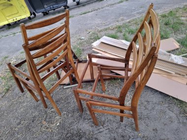 Koltuksuz ahşap sandalyeler ve kaplamalı döşeme tahtaları atıldı ve çöp konteynerlerinin yanına bırakıldı.