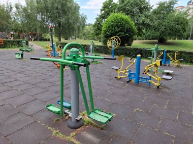 Şehir parkındaki açık hava spor sahası. Spor sahasında fiziksel aktivite için egzersiz aletleri.