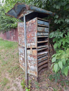 Kırsal kesimde eski, metal bir posta kutusu. Mektuplar ve gazeteler için paslı bir Sovyet posta kutusu.