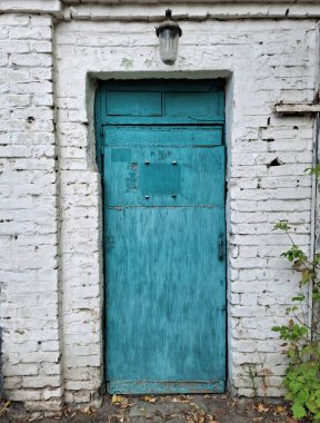 Eski mavi kapı. Kapının üstünde fener asılı.