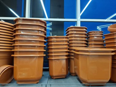 Süpermarket raflarında bir sürü büyük kahverengi saksı var. Plastik saksılar çiçekçide satılır.