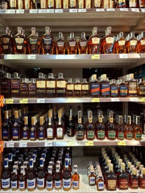 KYIV, UKRAINE, Kasım 7, 2025: Süpermarket raflarında farklı alkollü ürünler. Birçok alkollü içecek şişesi bir mağazanın alkollü içecekler bölümünde raflarda duruyor.