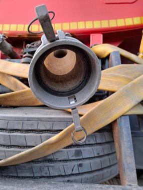 Tank kamyonu hortumu boşaltıyor. Tank hortumları. Tank kamyonları için lastik hortumlar. Hortumları ve yedek lastiği olan bir su tankeri kamyonunun arkasında. Bir tankerin su hortumu.