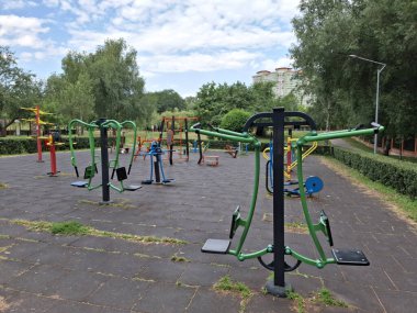 Şehir parkındaki açık hava spor sahası. Spor sahasında renkli egzersiz ekipmanları