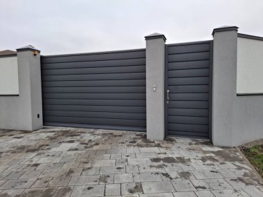 Yeni, modern bir kapı ve kır evinin girişindeki bir araba için sürgülü kapı.