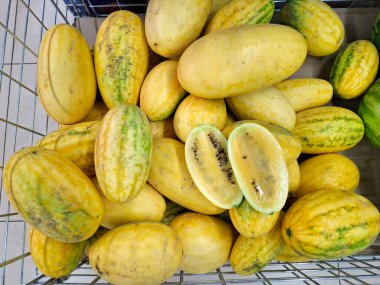 Sarı karpuz. Süpermarket raflarında sebzeler. Karpuz ve kavun karışımı. Markette taze sebzeler. Market tezgahları olgun mevsimlik sebzelerle doludur.