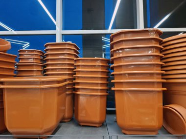 Plastik saksılar bir çiçekçide satılır. Süpermarket raflarında bir sürü büyük saksı var.