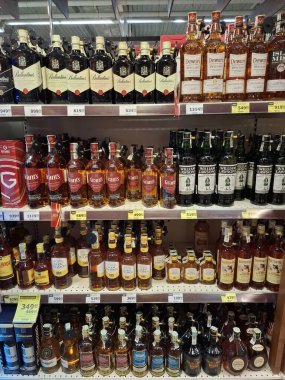 KYIV, UKRAINE, Kasım 7, 2025: Süpermarket raflarında farklı alkollü ürünler. Birçok alkollü içecek şişesi bir mağazanın alkollü içecekler bölümünde raflarda duruyor.