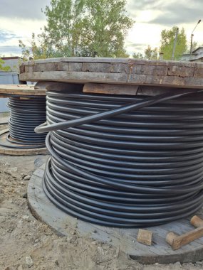 Büyük elektrik kablosu makaraları. Güç kablosu döşeniyor. Büyük makaralı siyah kablolar