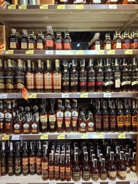 KYIV, UKRAINE, Kasım 7, 2025: Süpermarket raflarında farklı alkollü ürünler. Birçok alkollü içecek şişesi bir mağazanın alkollü içecekler bölümünde raflarda duruyor.