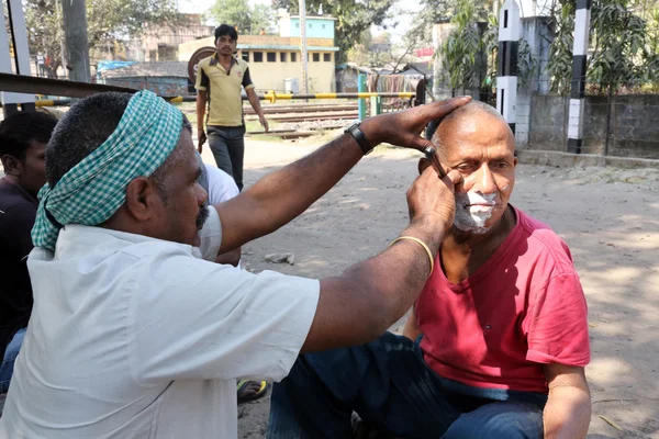 Ulica fryzjer golenie człowieka za pomocą otwartych żyletki na ulicy w Kalkucie — Zdjęcie stockowe