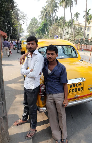 Indian taxi driver posing in front of his cab in Kolkata