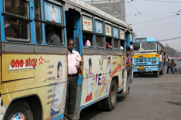 Люди на ходу приезжают на красочном автобусе в Калькутте — стоковое фото