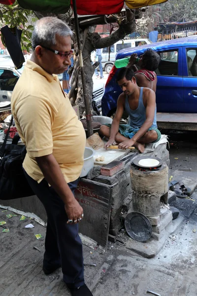 男は、コルカタに屋外単純な屋台の食べ物を準備します。 — ストック写真