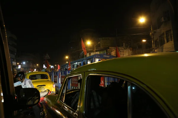 El tráfico oscuro de la ciudad se desdibujó en movimiento al atardecer en las calles llenas de gente, Kolkata, India — Foto de Stock