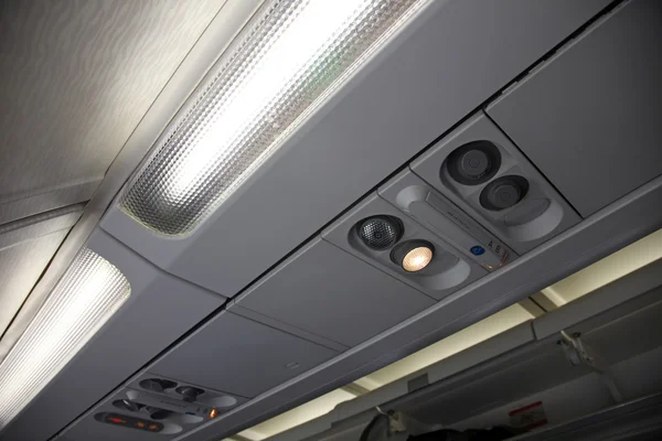 Kabina wewnątrz samolotu, światła, powietrza stan i znaki panelu nad siedzeniem — Zdjęcie stockowe