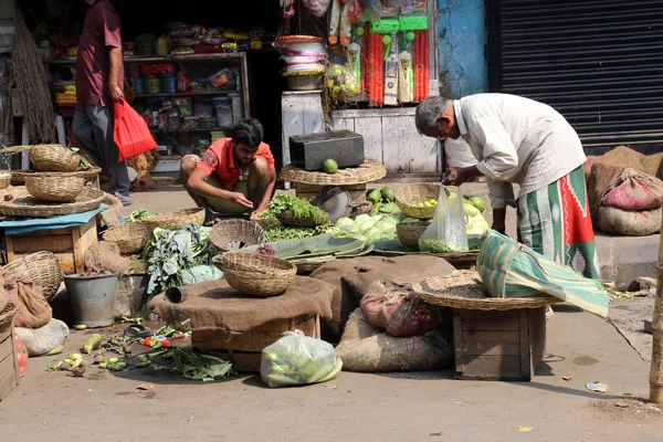 Straat handelaar verkopen groenten buiten op 12 februari 2014 in kolkata, india — Stockfoto