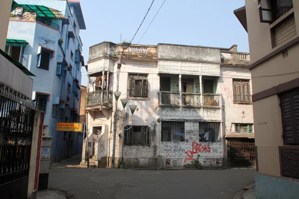 Um envelhecimento, decadente, bloco de arrendamento ex-colonial com lojas em Kolkata, Bengala Ocidental, Índia — Fotografia de Stock
