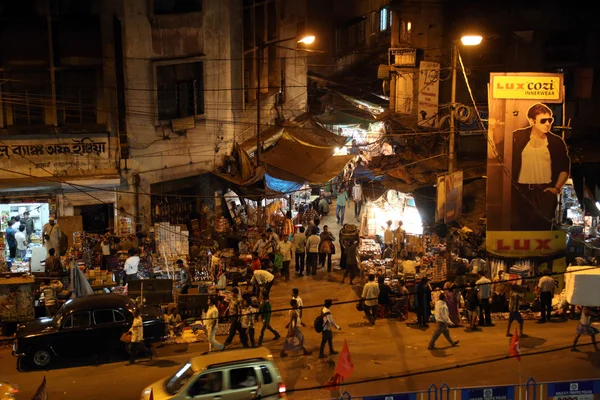 KOLKATA, INDIA - 10 DE FEBRERO DE 2014: El tráfico de la ciudad oscura borrosa en movimiento al atardecer en las calles llenas de gente de Calcuta — Foto de Stock