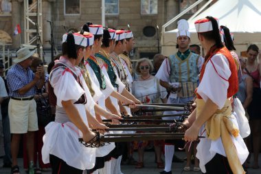 ZAGREB, CROATIA - JULY 18: Members of folk group Kumpanjija from Blato, island of Korcula, Croatia during the 49th International Folklore Festival in center of Zagreb, Croatia on July 18, 2015 clipart