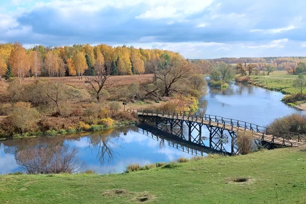 Autumn landscape with river and wooden bridge — Stock Photo, Image