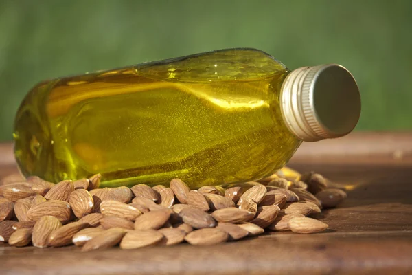 Almond oil in a bottle and almonds nuts — Stock Photo, Image