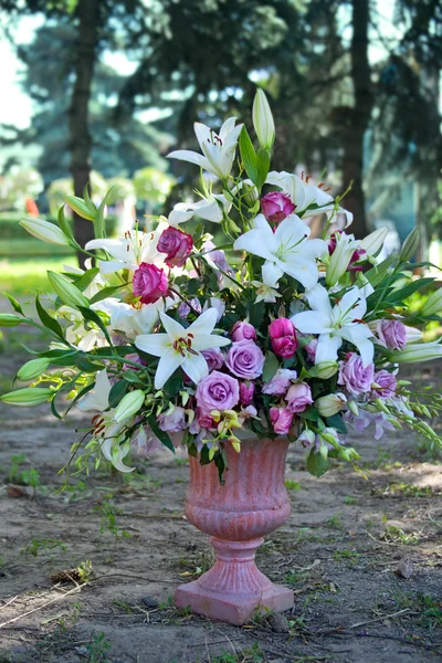 Букет квітів у кам'яній вазі в екстер'єрі міського парку — стокове фото