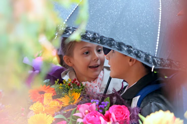Birinci sınıf öğrencisi kız ve erkek okulda bir şemsiye altında — Stok fotoğraf