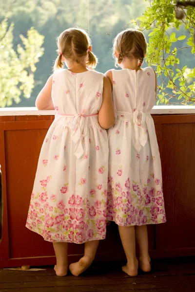 Twin girls on porch in summer dresses — Stock Photo, Image