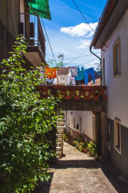 Yazın dar Portekiz caddesinde iki ev arasında küçük bir köprü