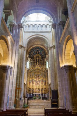 Tarihi bir taştan kilisenin heybetli, kubbeli sahanlığı ahşap sırıklarla kaplı, sıcak ve çevresel ışığın altında süslü, altın bir sunağa açılıyor.