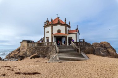 Kırmızı kiremitli çatısı ve beyaz duvarları olan tarihi bir şapel okyanusa bakan kayalık uçurumların tepesinde, kumlu bir sahilden taş merdivenlerle ulaşılıyor.