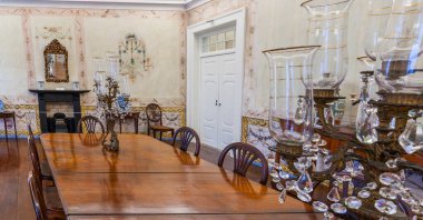 Biscainhos Müzesi. - Braga. Bu geniş yemek odasında süslü kristal şamdanlar ve zarif dönem sandalyeleriyle çevrili uzun, parlak bir ahşap masa seti bulunuyor. Duvarlar narin neoklasik freskler ve geleneksel ezgilerle süslenmiş.