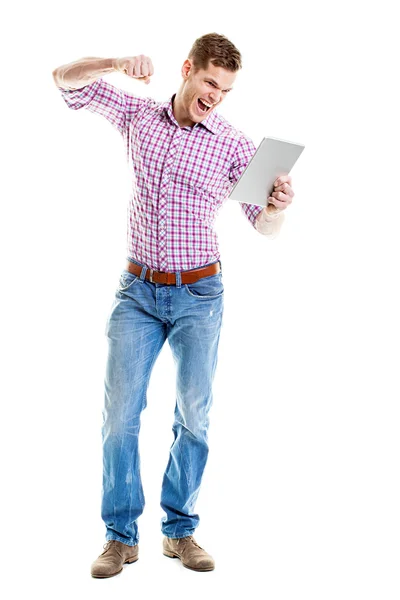 Angry young man ponsen zijn tablet pc met zijn vuist — Stockfoto