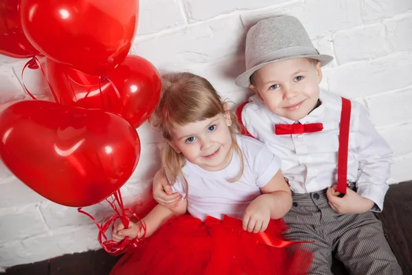 Des petits enfants tenant et ramassant des ballons cardiaques. Saint Valentin et concept d'amour, sur fond blanc — Photo