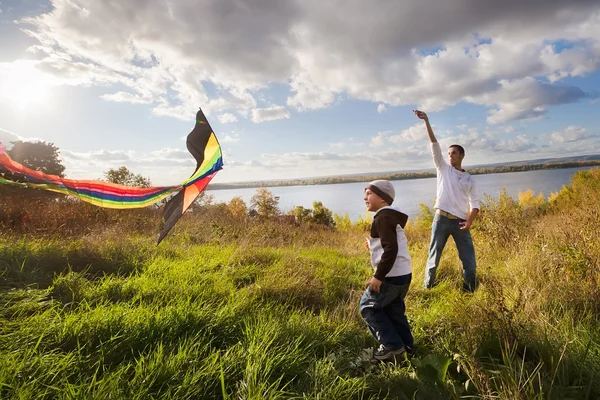 Far med son i höst spelar med kite — Stockfoto