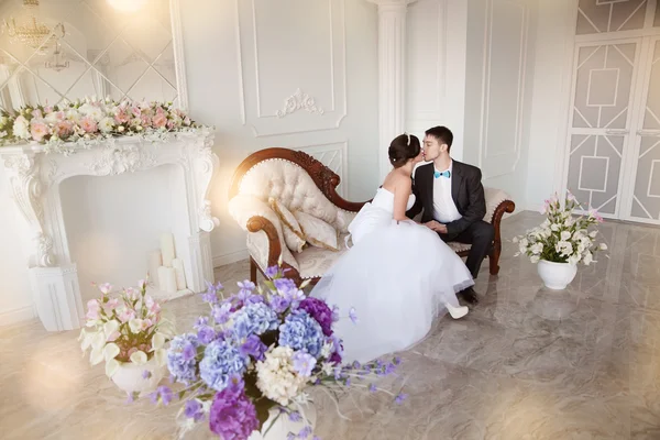 Noiva e noivo em um interior decorado com flores — Fotografia de Stock
