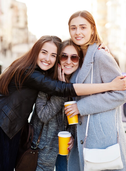 Three young women, best friends smiling at the camera