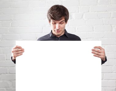 genç adam tuğla odasında posteri holding