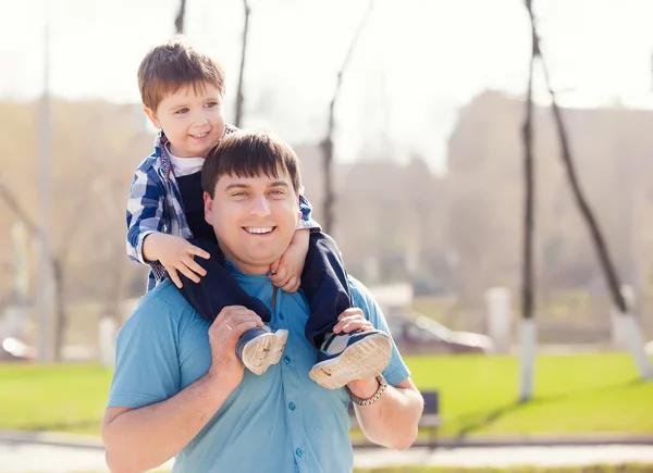 Son on fathers shoulders at the park having fun together — Stock Photo, Image