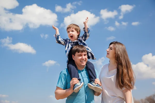 Семья из трех человек, молодые родители и маленький сын на фоне неба — стоковое фото