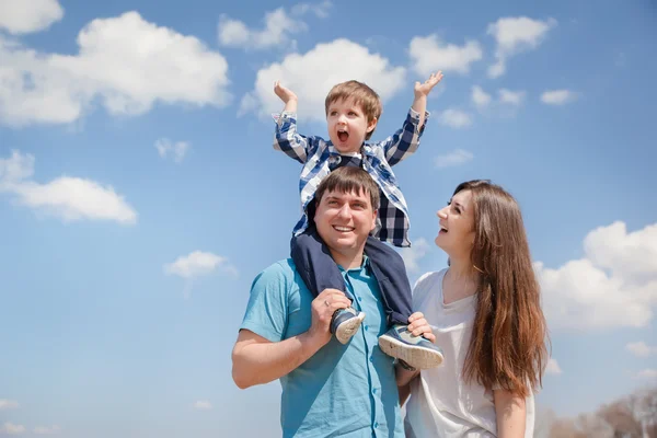 Família de três pessoas, pais jovens e um filho pequeno no fundo do céu — Fotografia de Stock