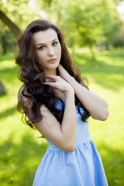 Portret van een mooie jonge Kaukasische vrouw in een lentetuin. — Stockfoto