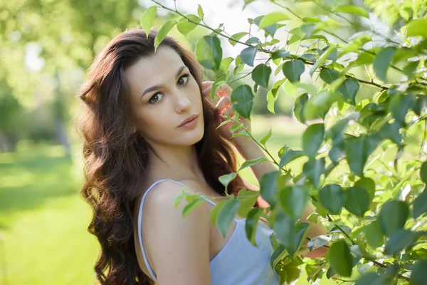Retrato de uma bela jovem mulher caucasiana em um jardim de primavera . — Fotografia de Stock