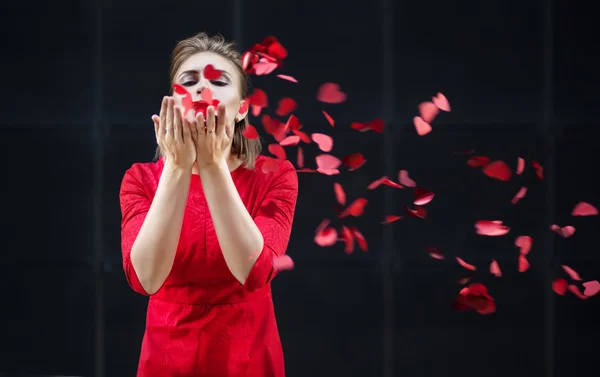 Conceito do Dia dos Namorados, mulher de vestido vermelho soprando em um coração de papel . — Fotografia de Stock