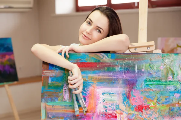 Kvinnelig kunstner som arbeider med maling i studio – stockfoto