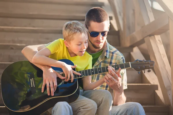 Padre aprendiendo su hijo a tocar la guitarra —  Fotos de Stock