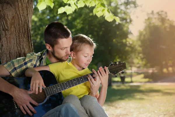 Father learning his boy to play guitar — Stock Photo, Image